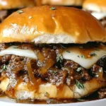 Juicy French Onion Beef Sloppy Joes with caramelized onions, melted Swiss cheese, and fresh thyme on a toasted bun.