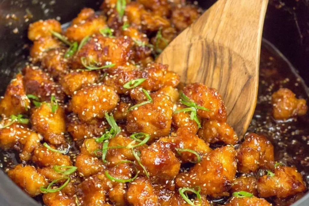 Slow Cooker Orange Chicken with sticky sweet sauce and sesame seeds in a crockpot