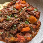 Slow Cooker Beef Ragu with tender vegetables served in a rustic bowl