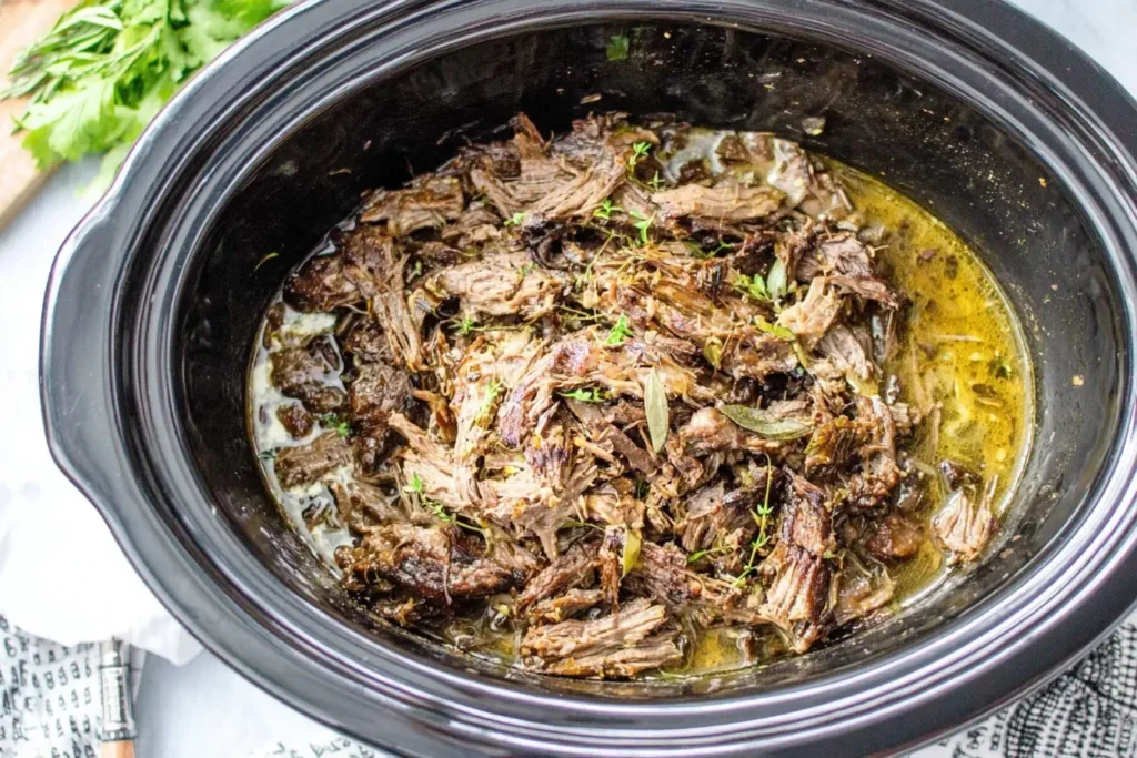 Shredded beef cooked in a slow cooker with herbs and juices, perfect for making Slow Cooker Beef Gyros.