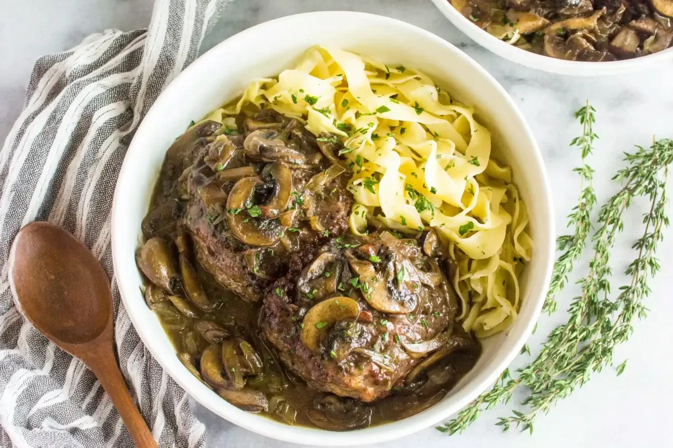Hearty Slow Cooker Salisbury Steaks with mushroom gravy and egg noodles