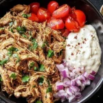 Slow Cooker Chicken Shawarma bowl with cherry tomatoes, red onions, creamy sauce, and fresh herbs.