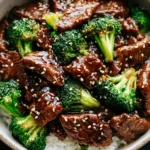 Crockpot Beef and Broccoli served over rice with sesame seeds on top.
