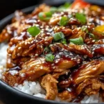 Slow Cooker Sweet Chili Chicken with sesame seeds and scallions served over rice and bell peppers.