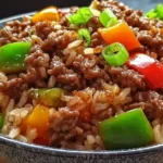 Close-up of a Beef Pepper Rice Bowl with ground beef, colorful bell peppers, and jasmine rice topped with green onions.