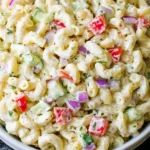 Bowl of creamy Gordon Ramsay Macaroni Salad with crunchy bell peppers, celery, cucumber, and red onion mixed in a tangy dressing.