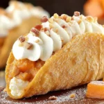 Close-up of Pumpkin Pie Tacos with whipped cream, cinnamon-sugar shell, and chopped pecan topping