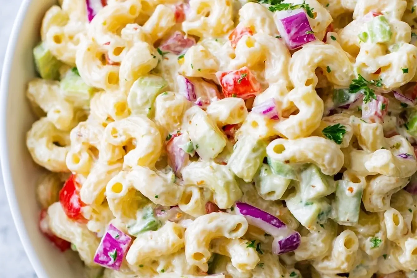 Close-up of creamy Gordon Ramsay Macaroni Salad with red onions, celery, and bell peppers coated in tangy dressing.