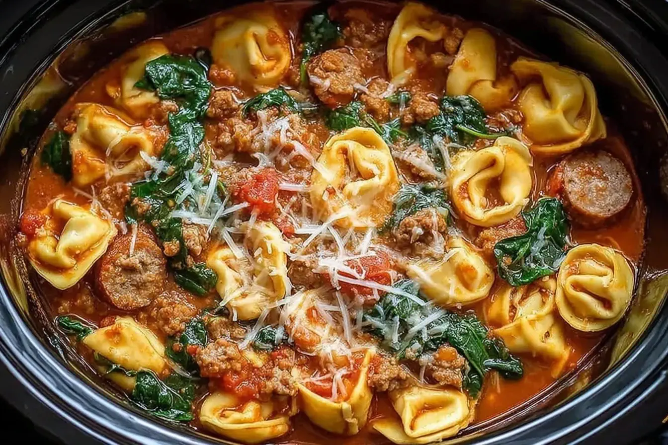 Crockpot Cheese Tortellini and Sausage with spinach, sausage, and a creamy tomato sauce in a slow cooker.