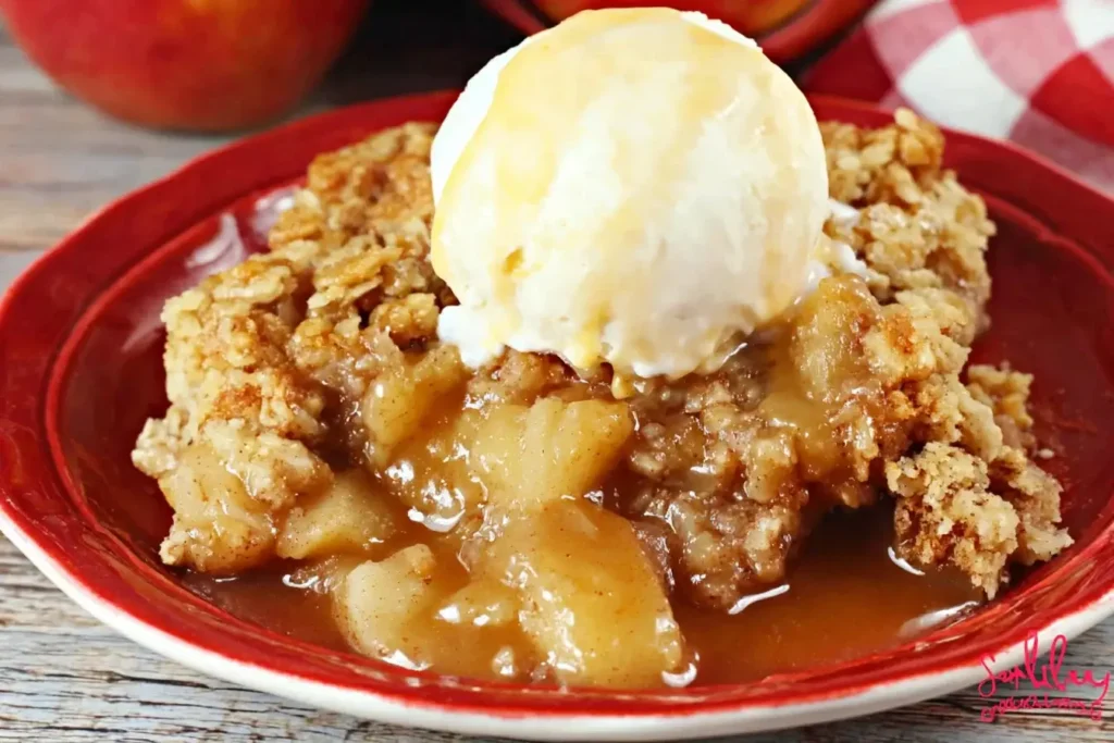 Warm Crock Pot Apple Dump Cake served with vanilla ice cream on a red plate