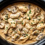 Crockpot Chicken Stroganoff with creamy sauce, tender chicken, and mushrooms, topped with fresh parsley.