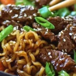 Close-up of Slow Cooker Beef Ramen Noodles with tender beef slices, green onions, and sesame seeds in a savory broth.