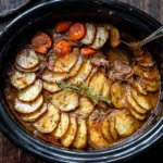 Slow Cooker Welsh Lamb Hotpot with layered potatoes, carrots, and tender lamb in rich gravy inside a black crockpot