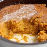 Slow Cooker Pumpkin Pie Pudding freshly cooked in a crockpot with a golden, set top and creamy center