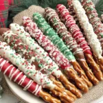 Christmas Pretzel Rods Recipe with festive chocolate-dipped pretzel rods decorated in red, green, and white sprinkles on a holiday plate.