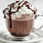 Decadent mug of No-Brainer Crockpot Slow Cooker Hot Chocolate Recipe with whipped cream and chocolate syrup drizzle.