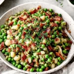 Thanksgiving Peas Pancetta served in a rustic bowl with crispy pancetta, sweet peas, and fresh herbs for a festive and flavorful holiday side dish.