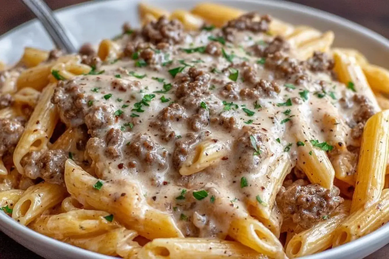 Slow Cooker Creamy Garlic Beef Pasta with tender beef, creamy garlic sauce, and parsley served over penne pasta