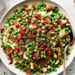 Thanksgiving Peas Pancetta with crispy pancetta, tender peas, and fresh herbs served in a white bowl for a cozy holiday side dish.
