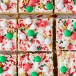 Top view of Christmas Sugar Cookie Bars decorated with colorful holiday sprinkles, candies, and frosting in neatly cut squares.