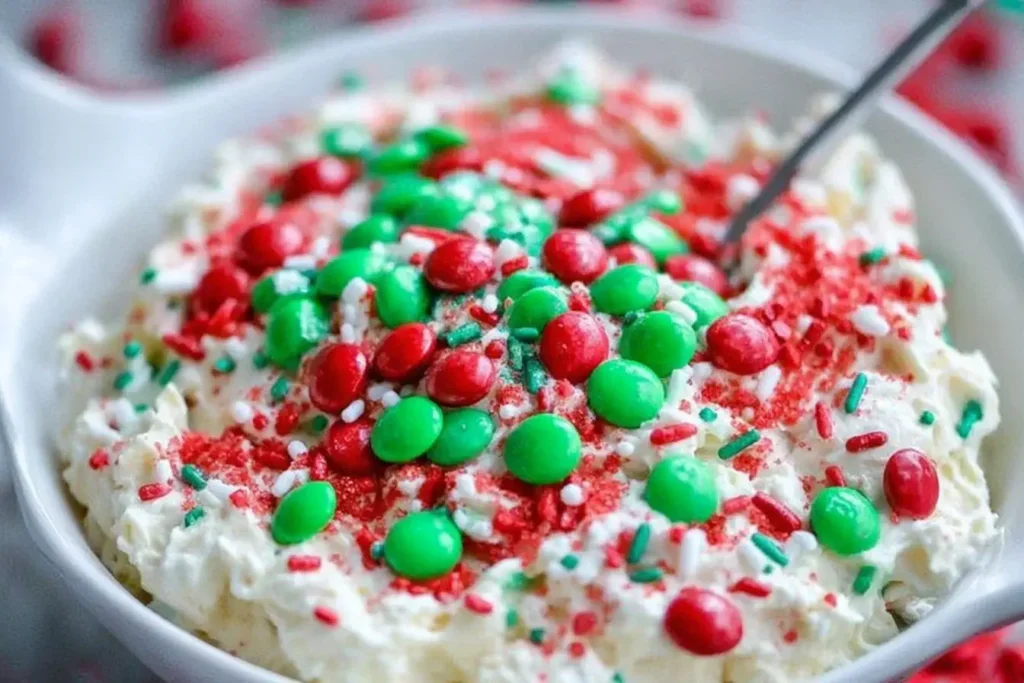 Close-up of festive Christmas Cookie Dip with red and green M&Ms and sprinkles.