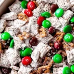 Close-up of Reindeer Food Recipe (Christmas Puppy Chow) with Chex cereal, pretzels, and red and green M&Ms coated in powdered sugar for a festive Christmas treat.