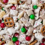 Close-up of Gluten Free Reindeer Chow featuring Chex cereal, pretzels, popcorn, and festive red and green candies coated in white chocolate.