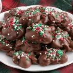 Christmas Crock Pot Candy topped with festive red, green, and white sprinkles displayed on a holiday plate.