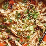 Classic Ginger Scallion Chicken Noodle Soup with tender chicken, noodles, scallions, and chili oil in a cozy broth.