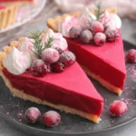 Slices of Cranberry Custard Pie topped with whipped cream and sugared cranberries on a dark plate