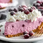 Cranberry Mousse Pie slice with creamy pink filling, gingersnap crust, and whipped cream topped with sugared cranberries