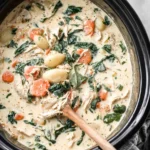 Creamy Crockpot Chicken Gnocchi Soup Recipe cooking in a slow cooker with shredded chicken, spinach, carrots, and gnocchi
