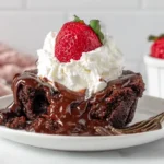 Crockpot Chocolate Lava Cake served warm with whipped cream and a fresh strawberry on top
