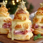 Ham & Cheese Puff Pastry Christmas Trees stacked with melted cheese and ham, topped with golden star decorations.