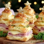 Ham & Cheese Puff Pastry Christmas Trees arranged on a wooden board with melted cheese, herbs, and star toppers.