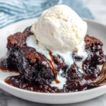 Slow Cooker Brownie Pudding with melting ice cream and gooey chocolate sauce