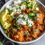 Slow Cooker Chicken Enchiladas served in a bowl with rice avocado sour cream and fresh cilantro