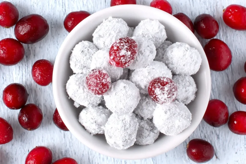 Candied Cranberries coated in powdered sugar in a white bowl