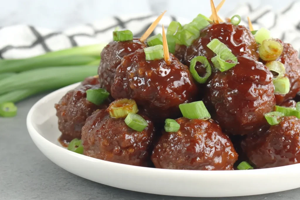 Sweet and Spicy Slow Cooker Meatballs served as an easy party appetizer with toothpicks and green onions