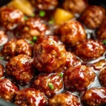 Slow Cooker Teriyaki Meatballs coated in a glossy homemade teriyaki sauce inside a crockpot.