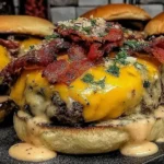 Crack Burgers loaded with melted cheddar, crispy bacon, and creamy sauce on toasted buns.