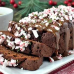 Peppermint Mocha Bread sliced on a platter, topped with chocolate drizzle and crushed peppermint candies, served with a warm cup of coffee