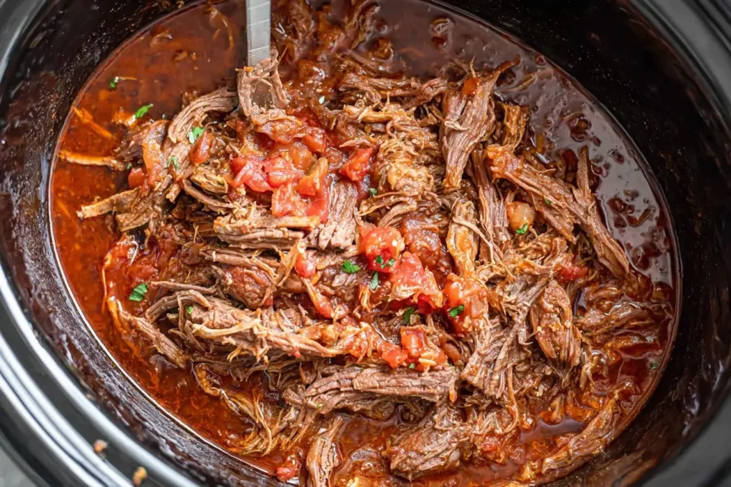 Crock Pot Beef Tacos with tender shredded beef and tomatoes in a rich sauce.