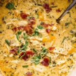 Slow Cooker Crack Chicken Soup simmering in a crockpot with shredded chicken, bacon, herbs, and creamy broth.