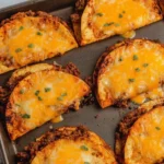 Sheet Pan Tacos on a baking sheet with seasoned ground beef and melted cheddar, baked until crispy and golden with a sprinkle of herbs.