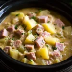 Creamy Slow Cooker Ham and Potato Casserole with tender potatoes, diced ham, and parsley served in a black bowl.