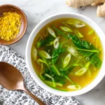 10 Minute Immune Boosting Broth served in a mug with ginger and garlic