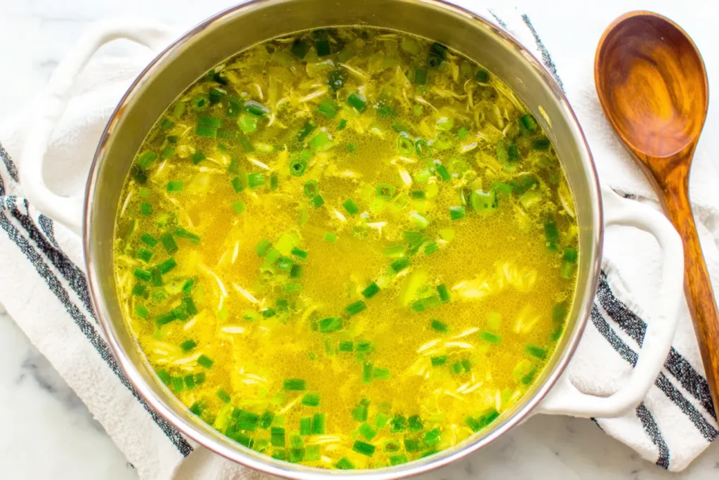 10 Minute Immune Boosting Broth simmering in a pot with green onions