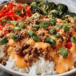 Bang Bang Ground Turkey Rice Bowls topped with ground turkey, vegetables, sesame seeds, and spicy creamy sauce