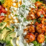 Buffalo Chicken Bowls with cheesy rice, lettuce, avocado, tomatoes, and ranch dressing